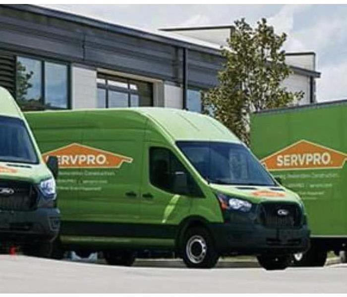 Green SERVPRO trucks are shown lined up.